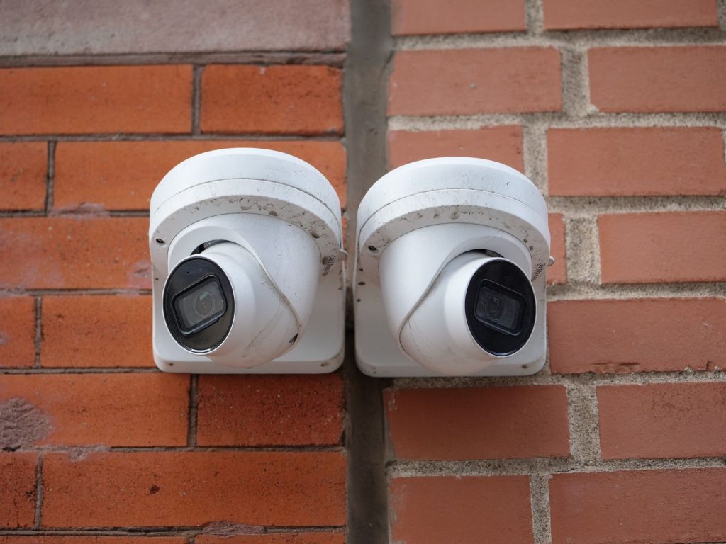 Two turret security cameras mounted on a brick wall